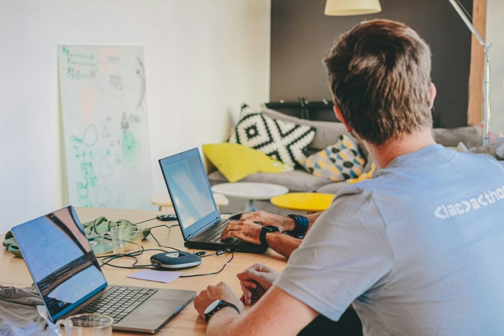 Man working on laptops at a desk.